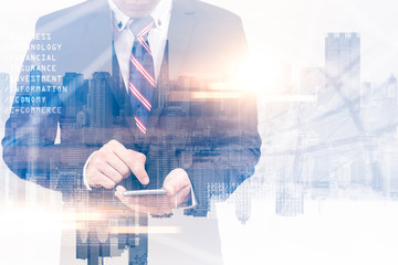 The double exposure image of the businessman using a smartphone during sunrise overlay with cityscape image. The concept of modern life, business, city life and internet of things.