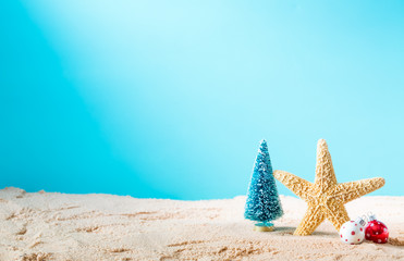 Fototapeta na wymiar Starfish with Christmas ornaments on a beach sand