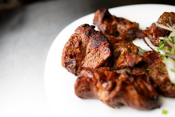 Shashlik with vegetables on a white plate