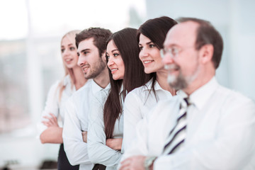 concept of team work - the leader and the business team standing one behind the other