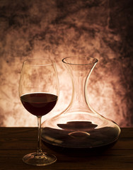 Decanter with red wine and glass on table