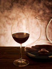 Decanter with red wine and glass on table