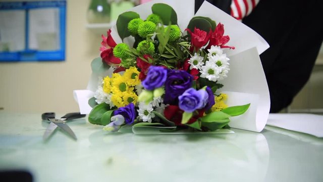 HD Florist packs up flower bouquet in a craft papper