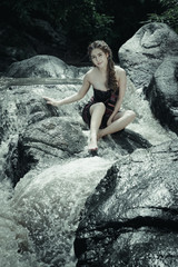 Young asian girl lady sexy and smiling relaxation sit bathing in a natural forest waterfall 
