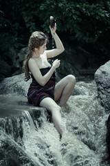 Young asian girl lady sexy and smiling relaxation sit bathing in a natural forest waterfall 