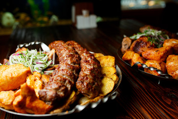 Lula kebab with vegetables. Minced mutton chop on the big steel plate
