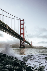 Golden Gate Bridge view from coast line, ocean waves