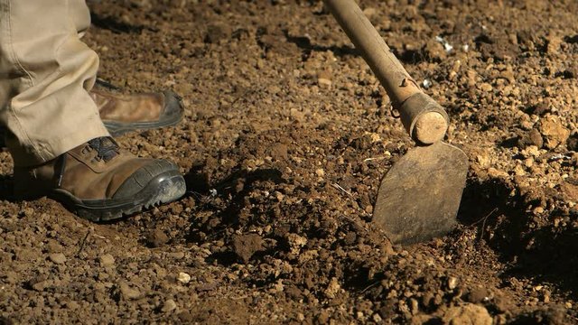 Rural man using hoe to plow by hand land soil