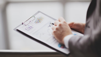 close up.businessman checking sales schedule.photo on blurred background