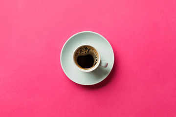 Blue cup of coffee on a colorful pink background. top view with copy space. morning concept