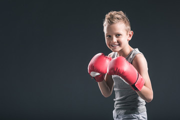portrait of cheerful boy with red boxing gloves on black backdrop © LIGHTFIELD STUDIOS