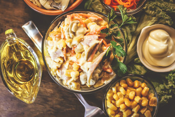salad of corn, mushrooms, chicken and carrots. ingredients. on a wooden table.