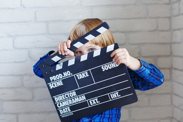 Little boy holds clapper board