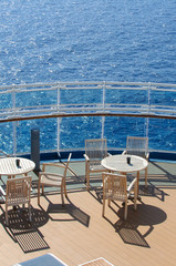 Obraz premium View from the deck of a cruise ship in the ocean. Seating area for passengers, chairs and sun loungers. Sunbathe.