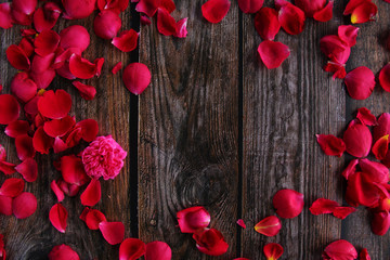 Red rose flower petal on wooden background 