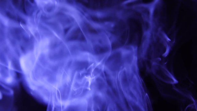 Blue Steam Rises from up. Blue smoke over a black background. Smoke slowly floating through space against black background. Slow Motion.