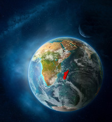 Madagascar from space on Earth surrounded by space with Moon and Milky Way. Detailed planet surface with city lights and clouds.