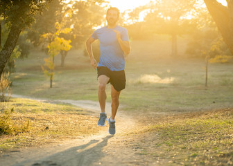 Athletic young man running in the nature at sunset in autumn in fitness Healthy lifestyle
