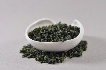 Chinese green tea in tea ware. Infusions. Heap of dry tea leaf.