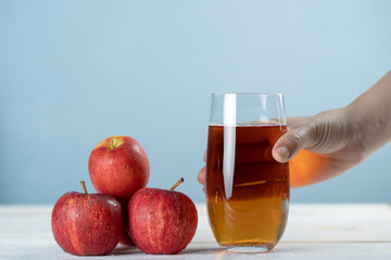 Hand holding Fresh apple juice in the glass