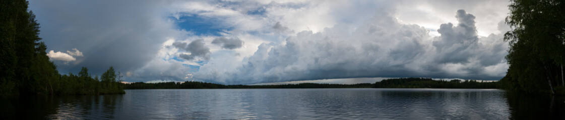 Naklejka na ściany i meble Storm clouds over lake landscape panorama