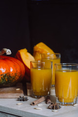 Fresh pumpkin juice with cinnamon on dark background