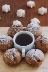 A cup of coffee with cookies on a wooden table.