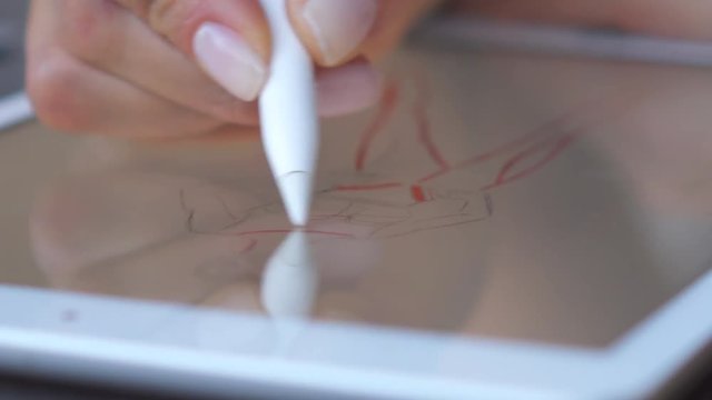 Fashion designer drawing on digital tablet