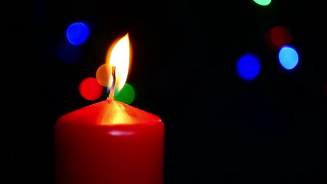 Close-up of a New Year's candle on the background of boke. Slow motion candle flame. Religion, spirituality and celebration.