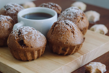 A cup of coffee with cookies on a wooden table.