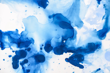 beautiful blue splashes of alcohol ink on white as abstract background