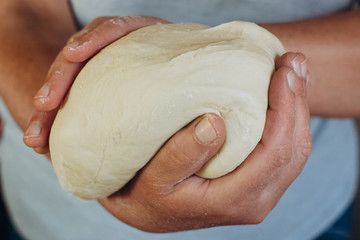 Hands kneading raw dough