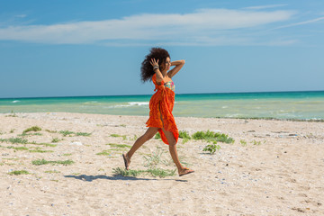 young happy woman dancing on the beach in summer