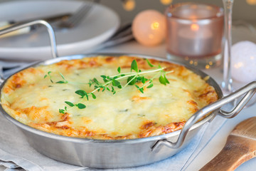 Cheesy scalloped potatoes or potato gratin in a baking dish, holiday theme, horizontal