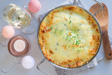 Cheesy scalloped potatoes or potato gratin in baking dish, holiday theme, horizontal, top view