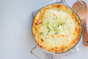 Cheesy scalloped potatoes or potato gratin in baking dish, holiday theme, horizontal, top view,...