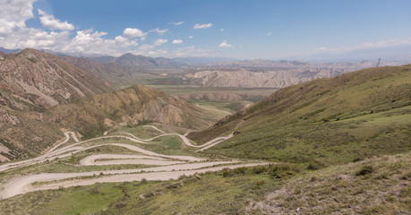 Kaldamo Pass Ak-kya – Kazarman Downhill or Level Roads. Mountains in Kyrgyzstan Near Kazarman. Gravel Curves in Kyrgyzstan