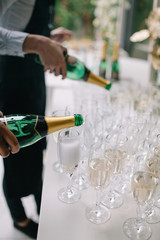 Fototapeta premium Pouring champagne into empty champagne glasses on event