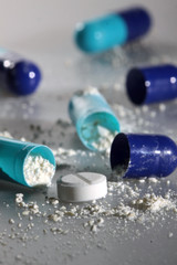 Opened blue pills with white powder close up