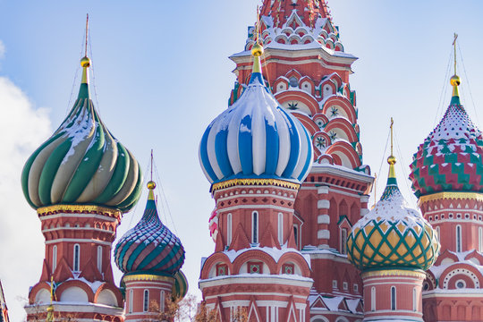 Domes of St Basil's Cathedral covered with snow on blue sky background