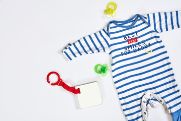 Baby care accessories and clothing on light background, top view