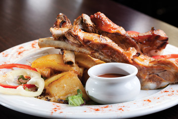 Close up of a pork ribs with BBQ sauce and potatos