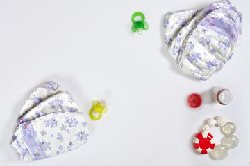 Babies goods diaper, soother or nipple on white background with copy space. Top view or flat lay.