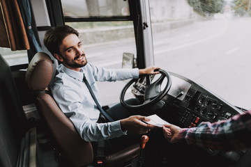 Smiling Young Driver taking Ticket from Passenger
