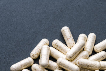 Beige Transparent Drugs, Pills, Vitamins (Dophilus) Scattered On A Gray Slate Background. Medical Series. Free Space For Text. Close Up. Angle View. Rustic Style.