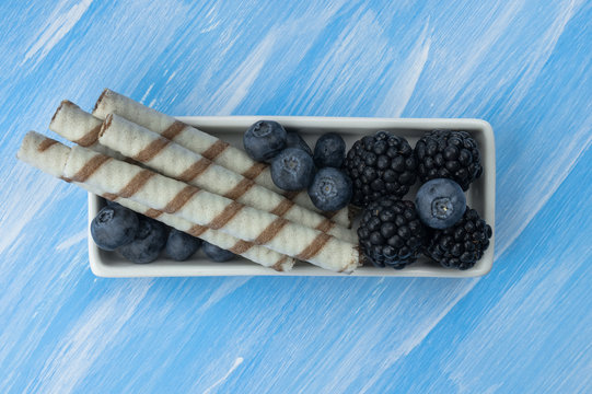 bowl of fresh blackberries and blueberries on a wooden background, close-up, horizontal