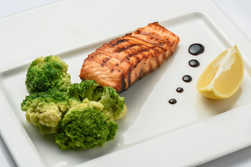 Baked fish salmon garnished with broccoli . Dietary menu. Fish menu. Seafood - salmon.