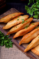 Fried chebureks with meat on a wooden board