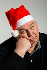 müder Nikolaus, erwachsener Mann mit Nikolausmütze, erschöpfter Ausdruck