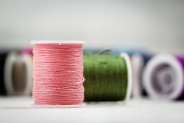 The roll of thread on background,show texture of soft pink color thread,needlework,craft,sewing and tailoring concept,blurry light design background